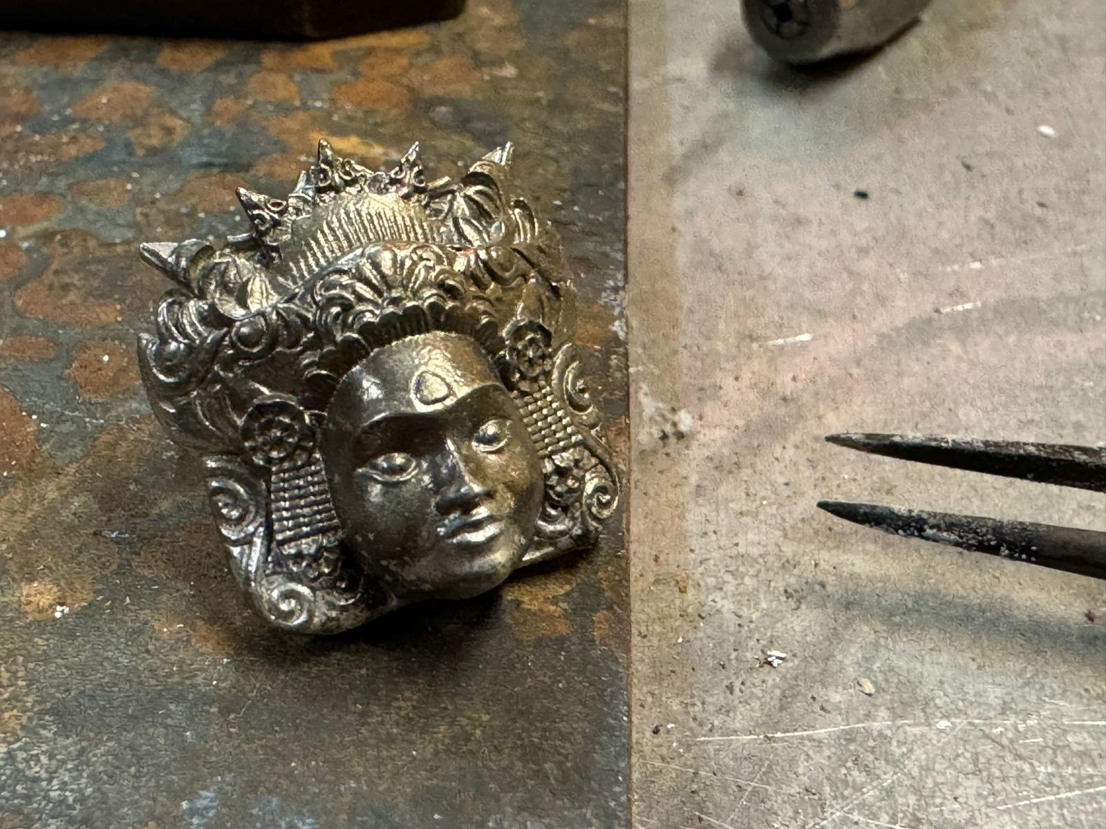 Silver pendant being finished on a Celuk workbench